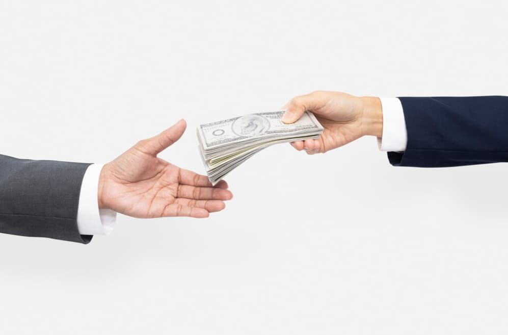 Hands exchanging money, depicting a financial transaction or deal